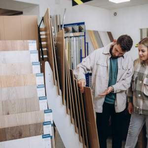 Young family couple choosing laminated material for home in modern store