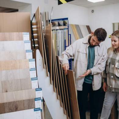 Young family couple choosing laminated material for home in modern store